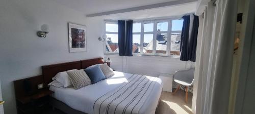 a bedroom with a bed and a window at Hotel De L'Europe in Perros-Guirec