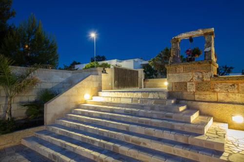 a set of stairs with lights at night at Trullo, con giardino privato, a pochi mt dal mare in Torre Suda