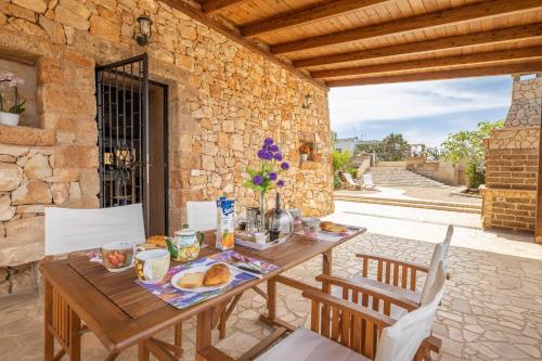 a wooden table with food on it on a patio at Trullo, con giardino privato, a pochi mt dal mare in Torre Suda