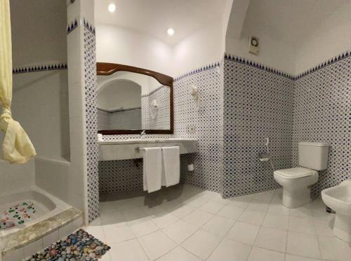 a bathroom with a toilet and a sink and a mirror at ℂoral Bay Dream - Luxury Sunset Sea View Apartment in Sharm El Sheikh