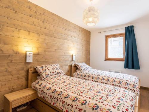 - une chambre avec 2 lits et un mur en bois dans l'établissement **Charmette: Duplex 4 Pièces, 8 Pers, 3 Ch, Parking Souterrain, Balcon** - FR-1-291-883, à Valmorel