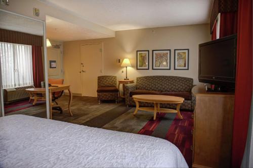 Habitación de hotel con cama y sala de estar. en Hampton Inn Cedar City, en Cedar City