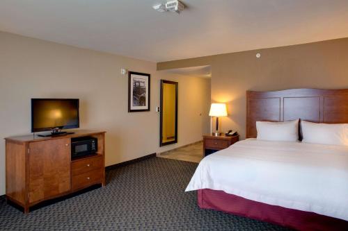 a hotel room with a bed and a flat screen tv at Hampton Inn Chickasha in Chickasha