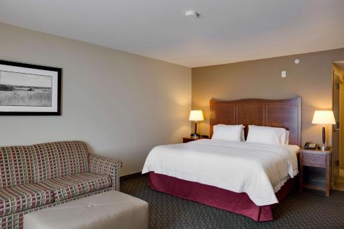 a hotel room with a bed and a couch at Hampton Inn Chickasha in Chickasha