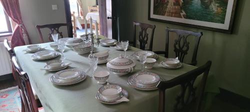 une table avec des assiettes, des tasses et de la vaisselle dans l'établissement Fiddlers Cottage, à Kesh