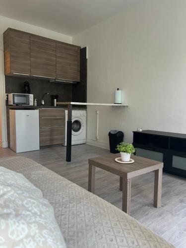 Zimmer mit einem Bett und einem Tisch sowie einer Küche in der Unterkunft Studio à 800m des plages in Marseille