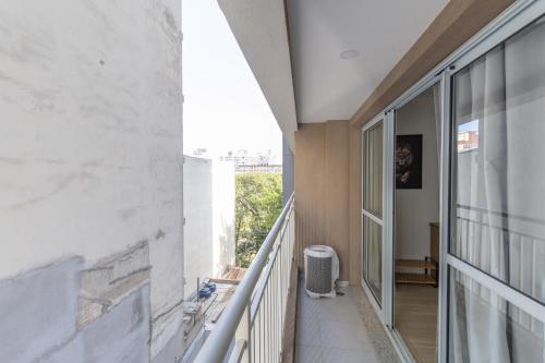 um corredor de uma casa com uma grande janela em MOL - Liberdade - Anora Spaces Residenciais em São Paulo