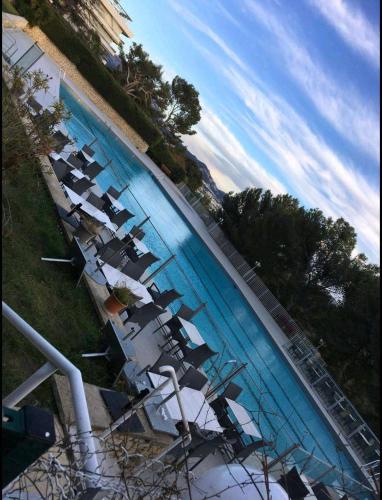 una fila de sillas sentadas en una piscina en Studio à 800m des plages, en Marsella