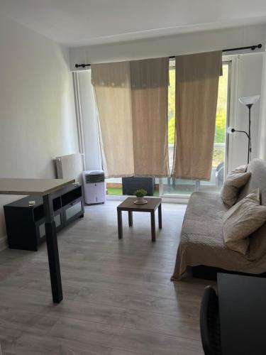 ein Wohnzimmer mit einem Bett und einem Tisch in der Unterkunft Studio à 800m des plages in Marseille