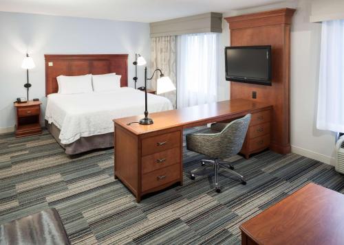 a hotel room with a bed and a desk with a computer at Hampton Inn & Suites Cedar Rapids in Cedar Rapids