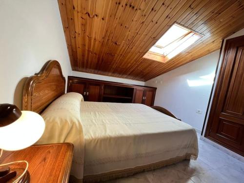 1 dormitorio con 1 cama con techo de madera en Ático completo de 3 habitaciones en O Barqueiro en O Barqueiro