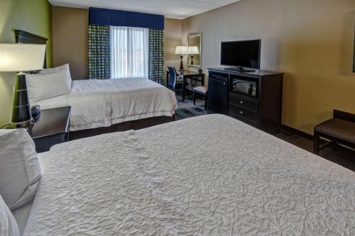a hotel room with two beds and a flat screen tv at Hampton Inn & Suites Clarksville in Clarksville