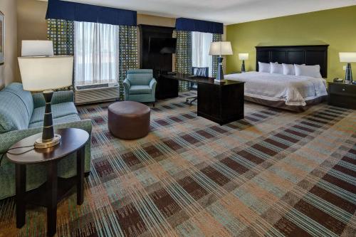 ein Hotelzimmer mit einem Bett und einem Sofa in der Unterkunft Hampton Inn & Suites Clarksville in Clarksville