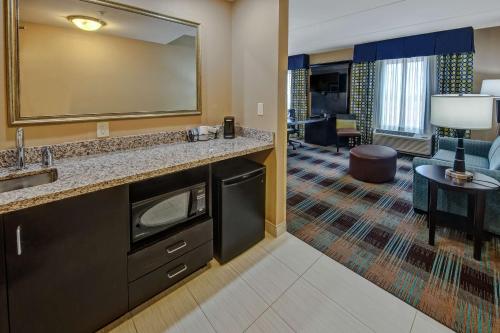 ein Hotelzimmer mit einem Waschbecken und einem Wohnzimmer in der Unterkunft Hampton Inn & Suites Clarksville in Clarksville