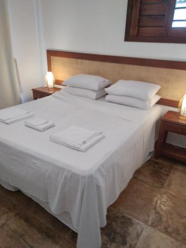 1 cama blanca grande con 2 toallas blancas. en Corais de Flecheiras, en Trairi