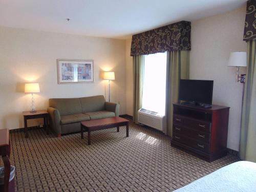 a hotel room with a couch and a television at Hampton Inn & Suites Cleveland-Mentor in Mentor
