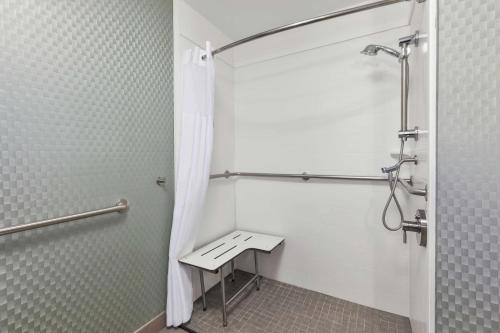 a shower stall with a bench in a bathroom at Hampton Inn Clinton in Clinton