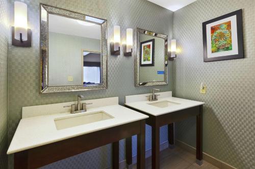 a bathroom with two sinks and two mirrors at Hampton Inn Clinton in Clinton