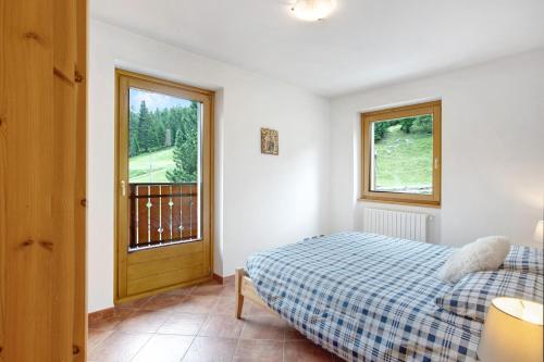 una camera con letto e finestra di Casa Michela Trilocale a Valfurva