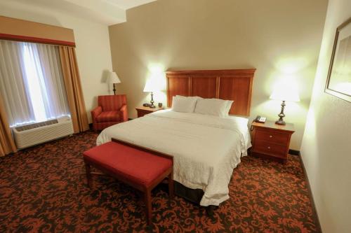 a hotel room with a bed and a red chair at Hampton Inn Lincolnton in Lincolnton