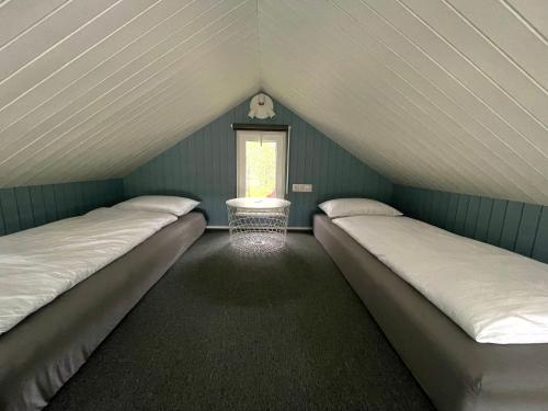 a attic room with two beds and a window at Amma Jóna in Hvolsvöllur