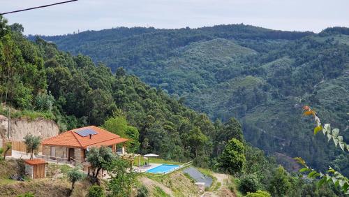 una casa junto a una montaña con piscina en CASA DO SOL , Turismo Rural, en Celorico de Basto