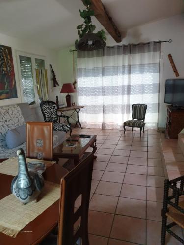 ein Wohnzimmer mit einem Sofa und einem Tisch in der Unterkunft Maison proche rivière in Ruoms