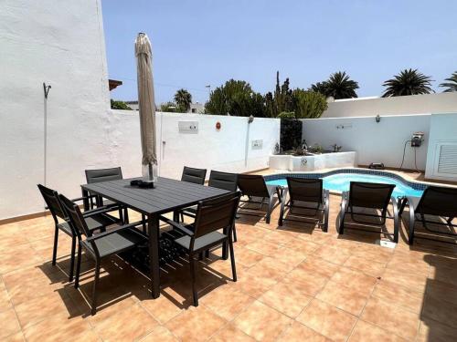 The Sallies - 3 bedroom villa with private pool في تياس: فناء مع طاولة وكراسي ومسبح