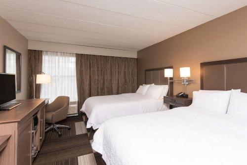 a hotel room with two beds and a flat screen tv at Hampton Inn Columbus/Taylorsville in Edinburgh