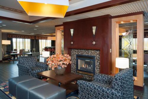 a lobby with a fireplace and chairs and a table at Hampton Inn Seymour in Seymour