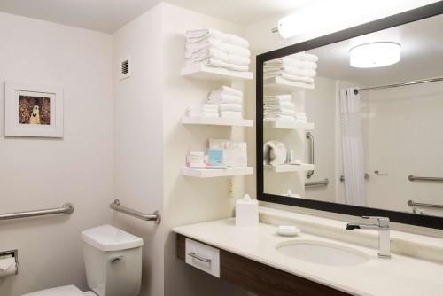 W białej łazience znajduje się umywalka i lustro. w obiekcie Hampton Inn Seymour w mieście Seymour