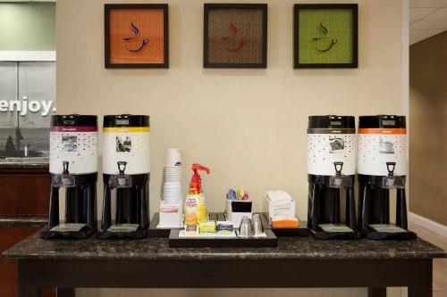 a counter with four coffee machines on a table at Hampton Inn & Suites Largo in Largo