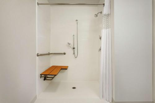 a shower with a wooden bench in a bathroom at Hampton Inn & Suites Largo in Largo