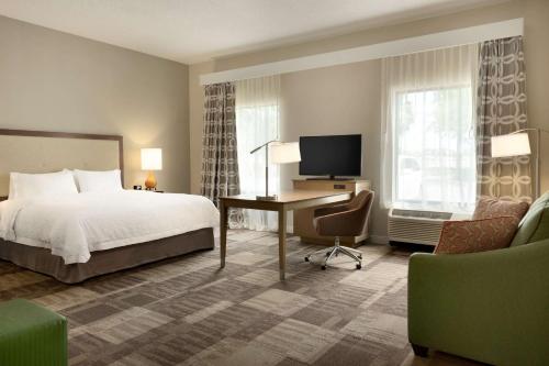 um quarto de hotel com uma cama e uma secretária com um computador em Hampton Inn & Suites Largo em Largo