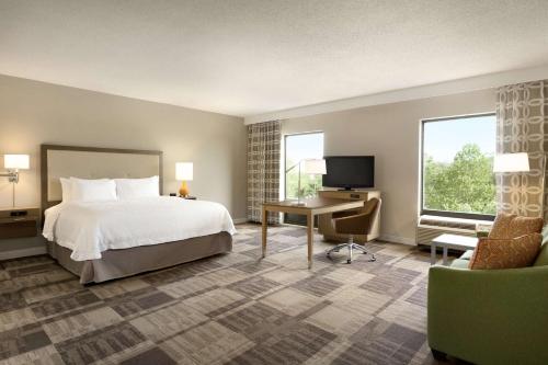 a hotel room with a bed and a desk and a tv at Hampton Inn & Suites Largo in Largo