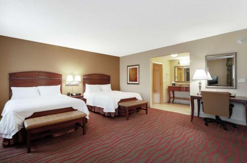 a hotel room with two beds and a bathroom at Hampton Inn & Suites Port Richey in Port Richey