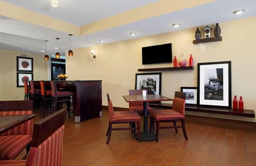 a restaurant with tables and chairs and a flat screen tv at Hampton Inn Columbus-International Airport in Gahanna