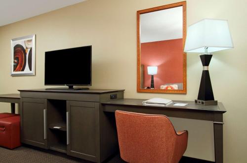 a room with a desk with a television and a lamp at Hampton Inn Columbus-International Airport in Gahanna
