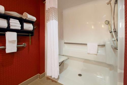 een badkamer met een douche, een toilet en handdoeken bij Hampton Inn Columbus-International Airport in Gahanna