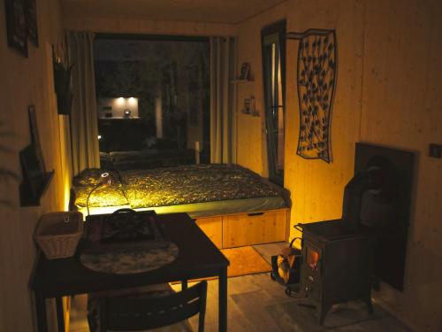 een kleine kamer met een bed, een tafel en een televisie bij Casita Colombia - Glamping v Brdech - Příbram 