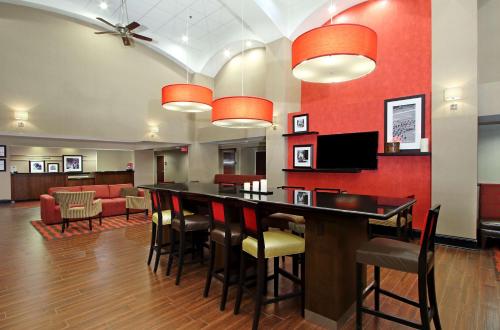 a bar in a hotel lobby with red walls at Hampton Inn & Suites Columbus Hilliard in Hilliard