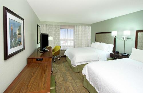 a hotel room with two beds and a flat screen tv at Hampton Inn & Suites Columbus Hilliard in Hilliard