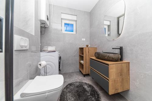 a bathroom with a toilet and a sink and a mirror at Rooftop New Castel 2023 in Kaštela