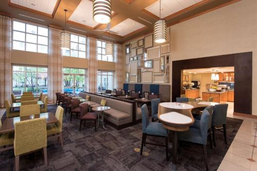 a restaurant with tables and chairs in a room with windows at Homewood Suites Columbus - Airport in Columbus