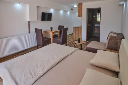 um quarto com uma cama, um sofá e cadeiras em Apartmani Tvins em Sokobanja