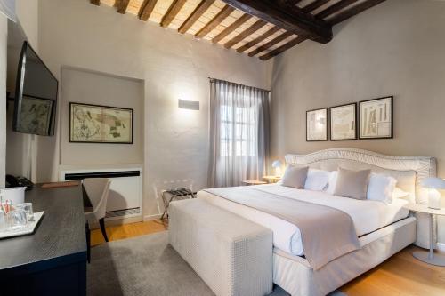 a bedroom with a large white bed and a desk at Relais Villa del Borgo in Canelli
