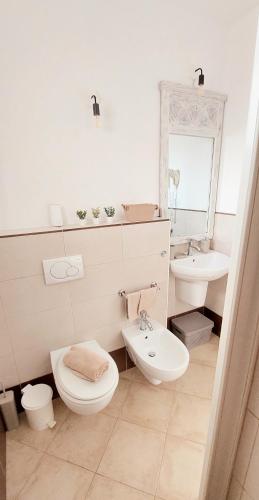 a white bathroom with a toilet and a sink at Sunset house Cabo Verde in Santa Maria