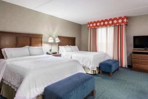 a hotel room with two beds and a flat screen tv at Hampton Inn & Suites Columbus Polaris in Columbus