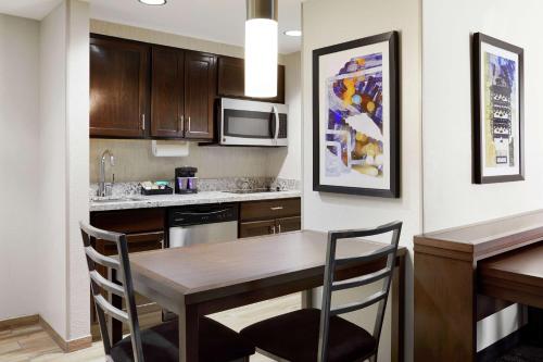 a kitchen with a table and chairs in a room at Homewood Suites Champaign-Urbana in Champaign