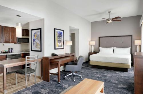 シャンペーンにあるHomewood Suites Champaign-Urbanaのベッド1台、デスク、ベッドルーム1室が備わります。